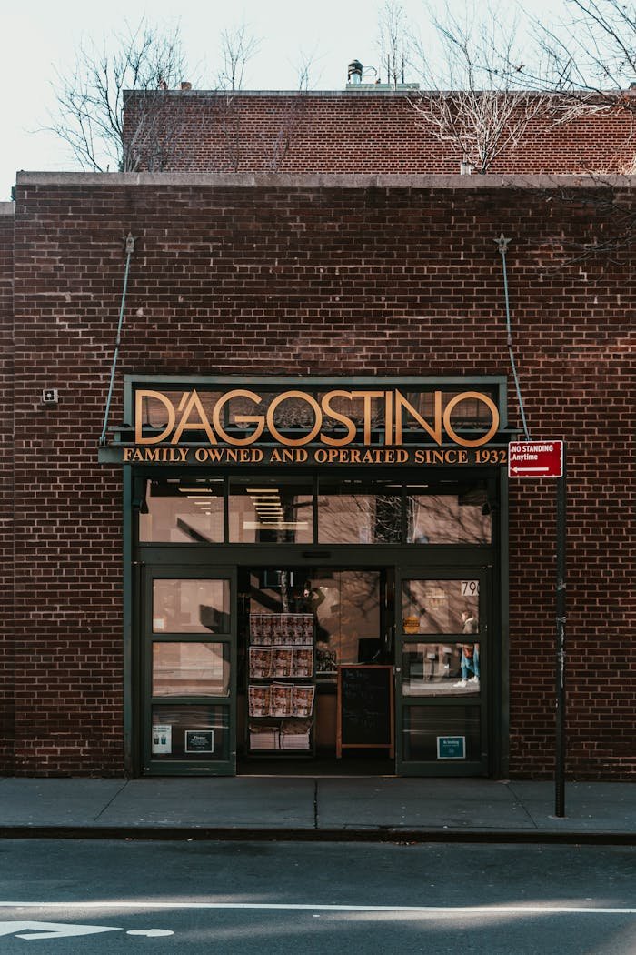 our-story Exterior view of DAgostino grocery store in NYC, showcasing its iconic brick facade.